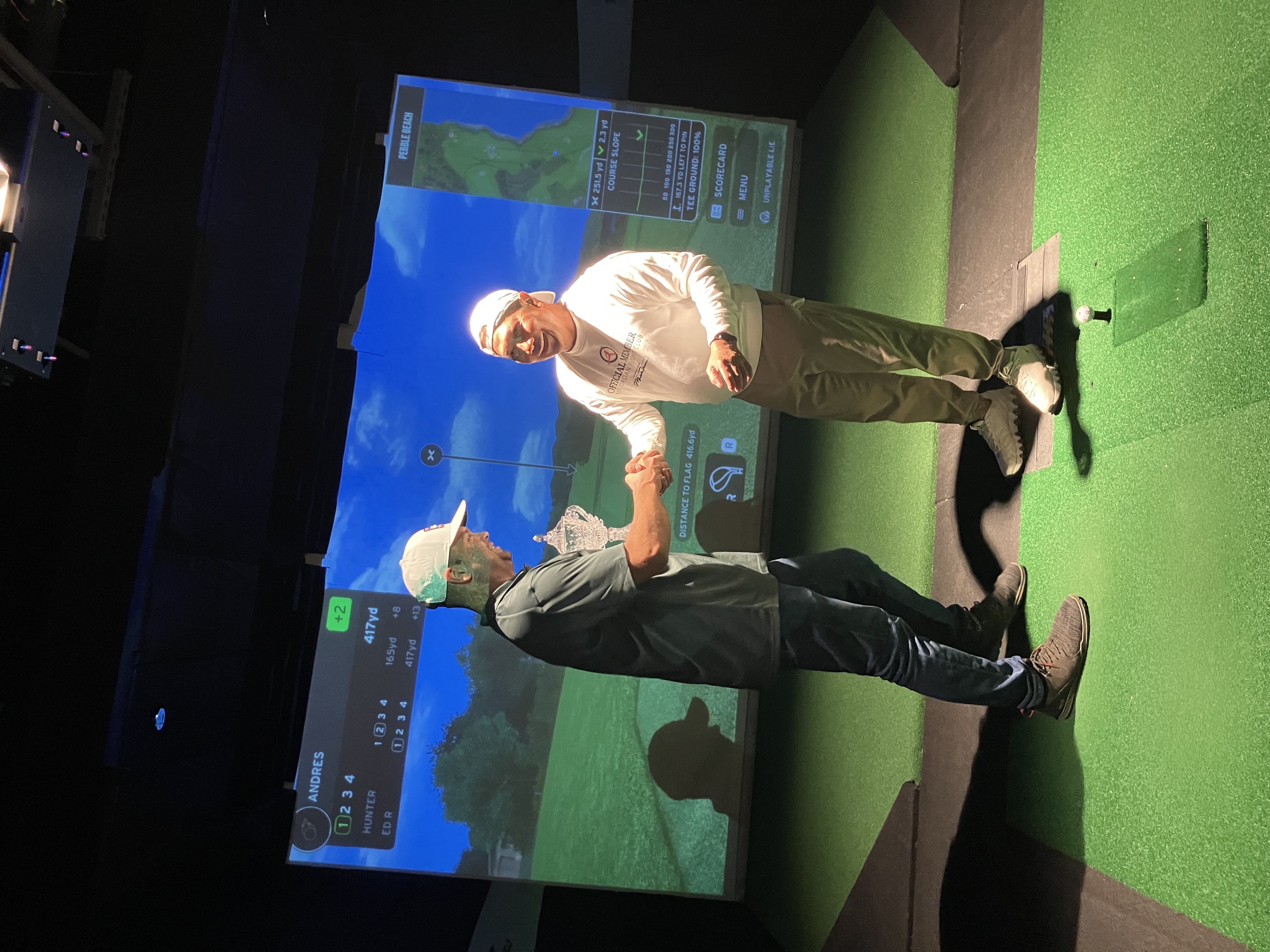 Simulator tournament handshake with championship trophy